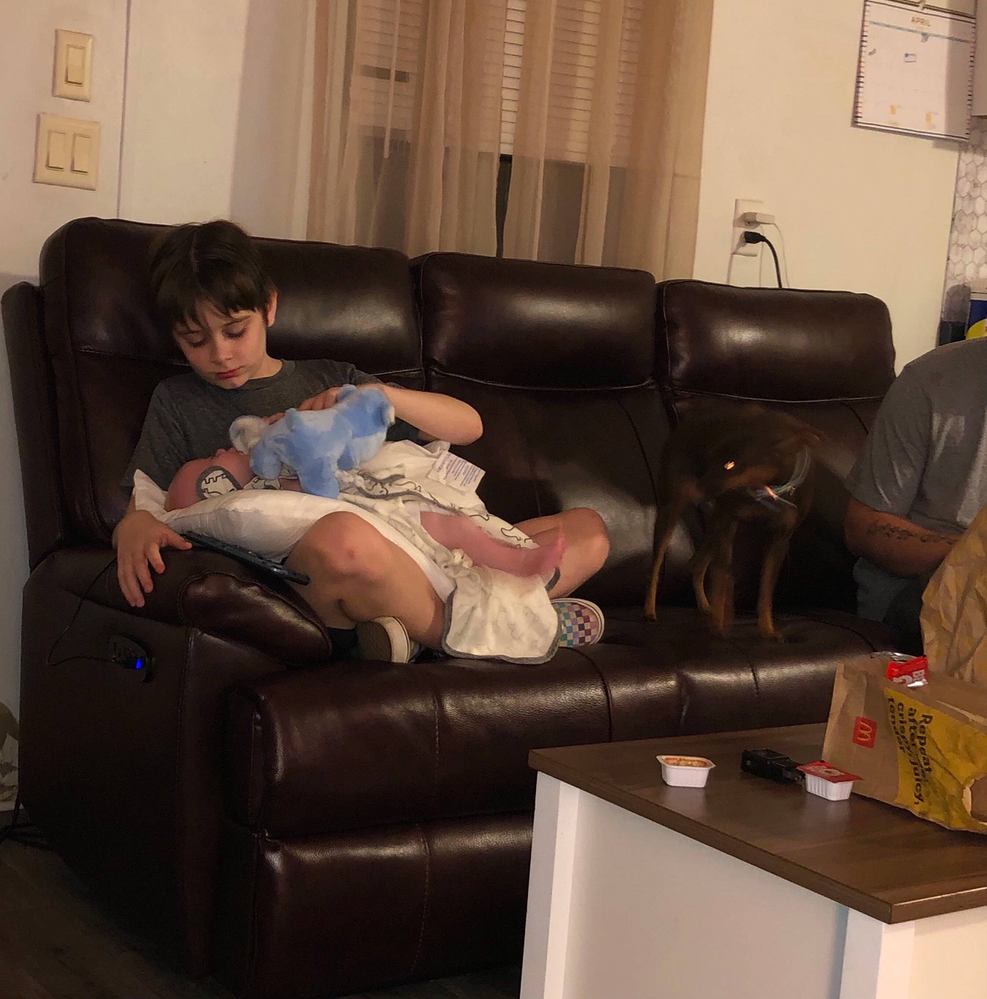 Sj is registered to the contest to win money with this photo: building, comfort, couch, electronic_device, floor, flooring, furniture, hardwood, interior_design, lamp, lap, lighting, living_room, mammal, person, picture_frame, sofa_bed, studio_couch, table, thigh