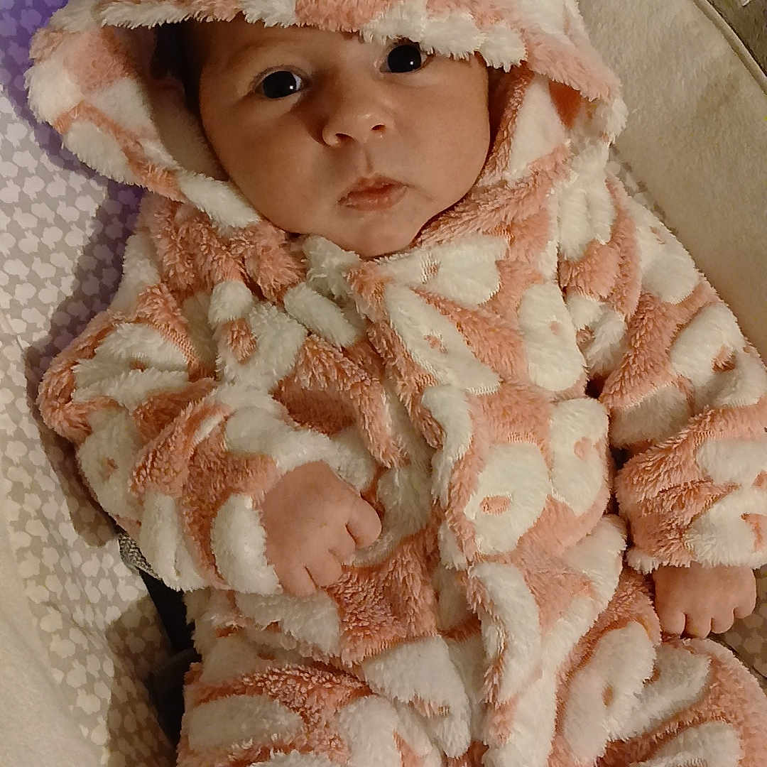 Cloëly participe au concours pour gagner de l'argent avec cette photo : animal_ears, baby, child, cozy, cushion, cute, eyes, face, fluffy, hand, hood, indoor, infant, onesie, pattern, pink, portrait, soft, warm, white