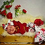 baby, sleeping, newborn, red_clothing, headband, floral_pattern, wooden_crate, fluffy_blanket, artificial_flowers, red_roses, green_leaves, cozy, portrait, indoor, soft_lighting, cute, infant, peaceful, decor, resting