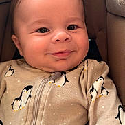 Ethan joined the competition — help win amazing prizes! baby, infant, smile, face, penguin_pattern, onesie, clothing, cushion, seat, child, cute, happy, portrait, closeup, indoors, skin, head, young, baby_clothes, warm