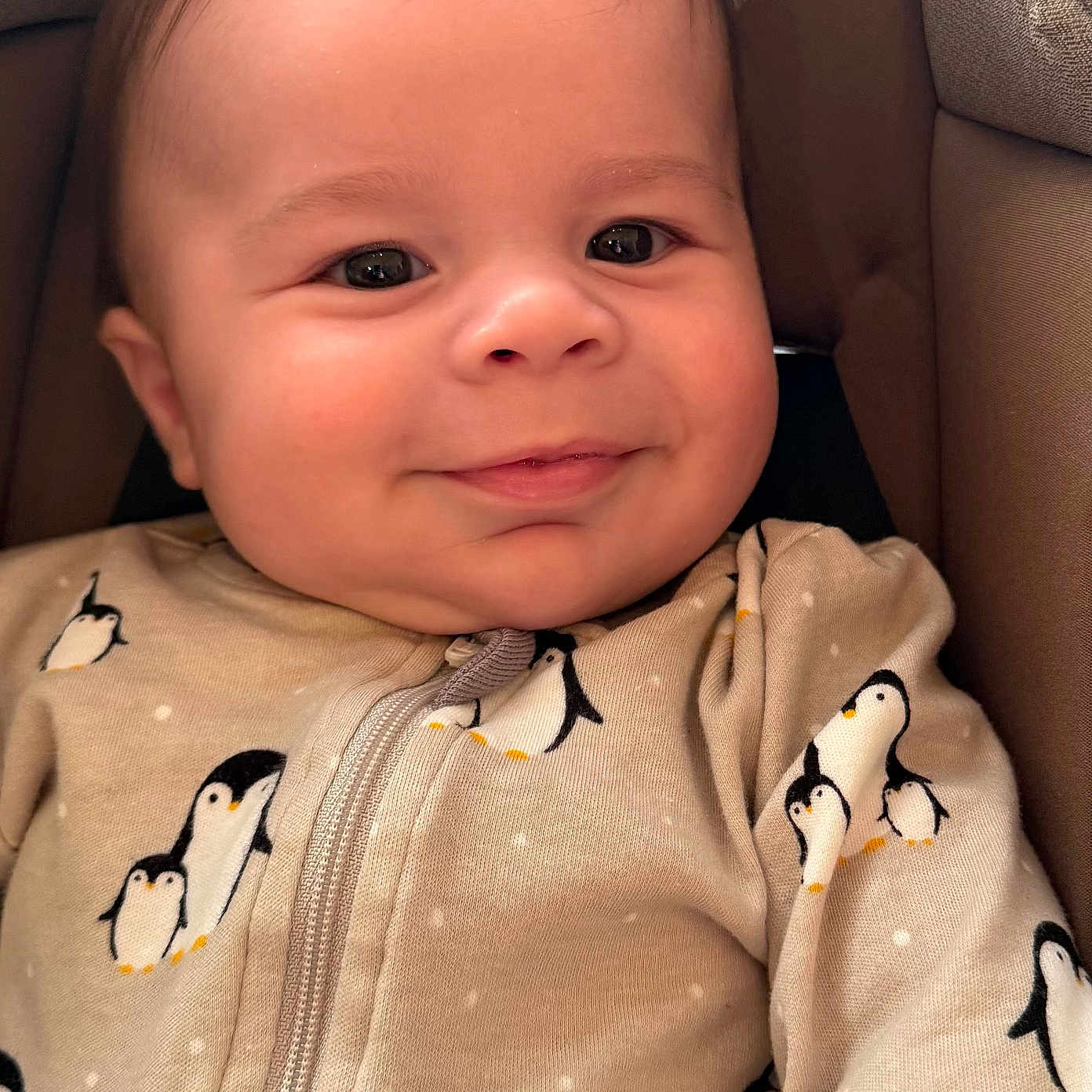 Ethan joined the competition — help win amazing prizes! baby, infant, smile, face, penguin_pattern, onesie, clothing, cushion, seat, child, cute, happy, portrait, closeup, indoors, skin, head, young, baby_clothes, warm