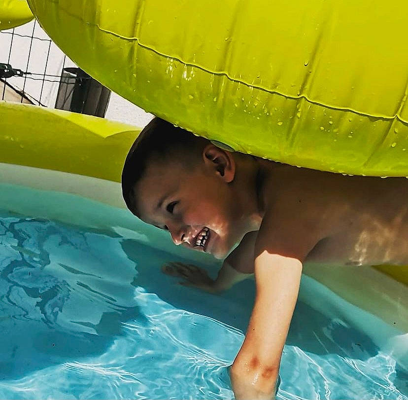 Mayron a rejoint le concours — aidez-le/la à gagner de superbes lots ! aqua, blue, cap, child, fun, grass, green, happy, hat, inflatable, leisure, nonbuilding_structure, person, personal_protective_equipment, product, recreation, smile, summer, toddler, water
