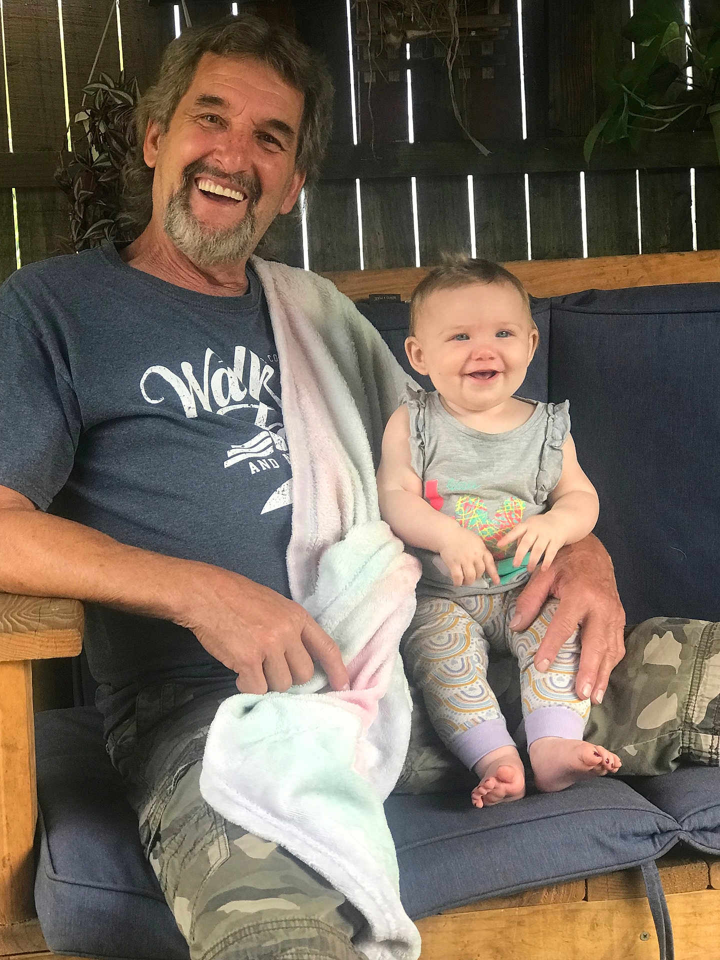 Harper joined the competition — help win amazing prizes! adult, baby, smiling, man, child, bench, cushion, blanket, casual_clothing, happy, portrait, indoor, wooden_furniture, family, holding, person, tshirt, camouflage, beard, blue_eyes