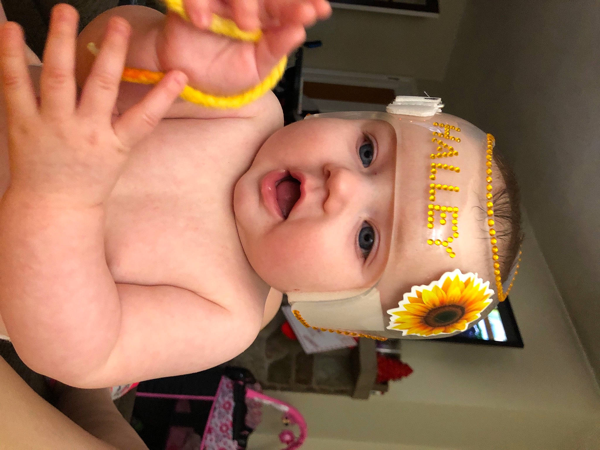 Halley is registered to the contest to win money with this photo: artificial_flower, baby, baby_products, baby_toddler_clothing, cheek, child, daisy_family, eyebrow, eyelash, finger, headwear, lip, nail, organ, person, skin, sunflower, throat, thumb, toddler