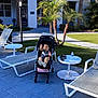 Edgar joined the competition — help win amazing prizes! toddler, stroller, child, outdoor, poolside, lounge_chair, palm_tree, table, water_bottle, keys, building, grass, sidewalk, sunlight, shadow, daytime, relaxation, vacation, summer, playful