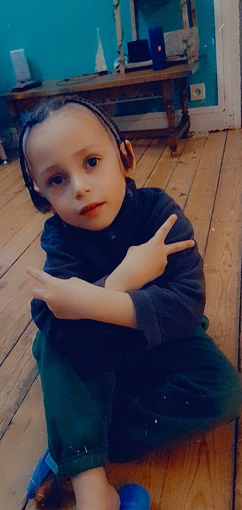 Rowenzo participe au concours pour gagner de l'argent avec cette photo : baby_toddler_clothing, blue, child, elbow, electric_blue, eye, flooring, fun, happy, hardwood, human_leg, iris, nose, person, sitting, sleeve, t_shirt, toddler, wood