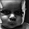 baby, black_and_white, child, close_up, dramatic_lighting, expression, eyes, face, head, human, innocence, intense_look, monochrome, person, photography, portrait, serious, skin_texture, studio_lighting, young_child