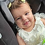 baby, car_interior, car_seat, child, closeup, cute, dress, hair_bow, happy, holding, indoor, infant, portrait, safety_label, seat, seatbelt, smile, toy, white_dress, young_child