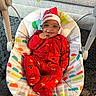 Carmello joined the competition — help win amazing prizes! baby, infant, child, christmas_hat, red_pajamas, baby_rocker, smile, happy, indoor, carpet, toy, face, person, cute, holiday, festive, clothing, seat, home, playful