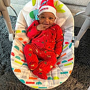 Carmello joined the competition — help win amazing prizes! baby, baby_rocker, carpet, child, christmas_hat, colorful, cozy, cute, furniture, happy, holiday, home, indoor, infant, person, portrait, red_pajamas, seat, smiling, toy_rings