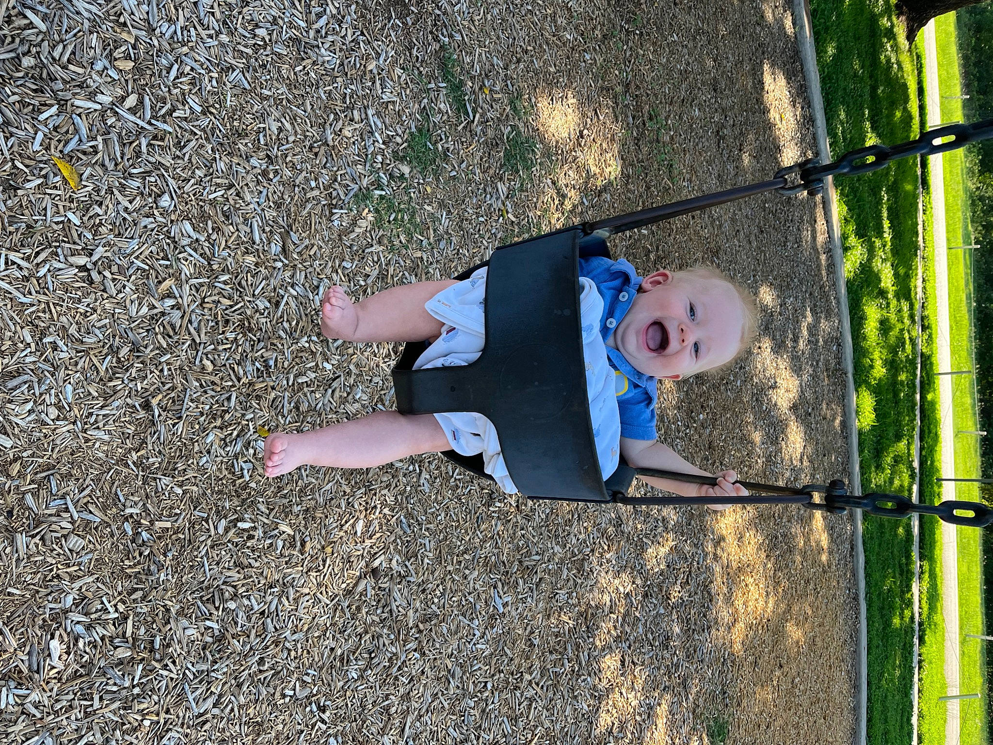 Leland is registered to the contest to win money with this photo: asphalt, child, concrete, electric_blue, fun, grass, hat, leisure, people_in_nature, person, recreation, road_surface, shadow, sidewalk, smile, soil, tar, toddler, toy, tree