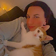 Ninja a rejoint le concours — aidez-le/la à gagner de superbes lots ! person, cat, indoor, couch, snuggling, cozy, relaxed, selfie, orange_and_white_cat, warm_lighting, casual_clothing, home, cute, pet, affection, morning, face, animal, comfort, love