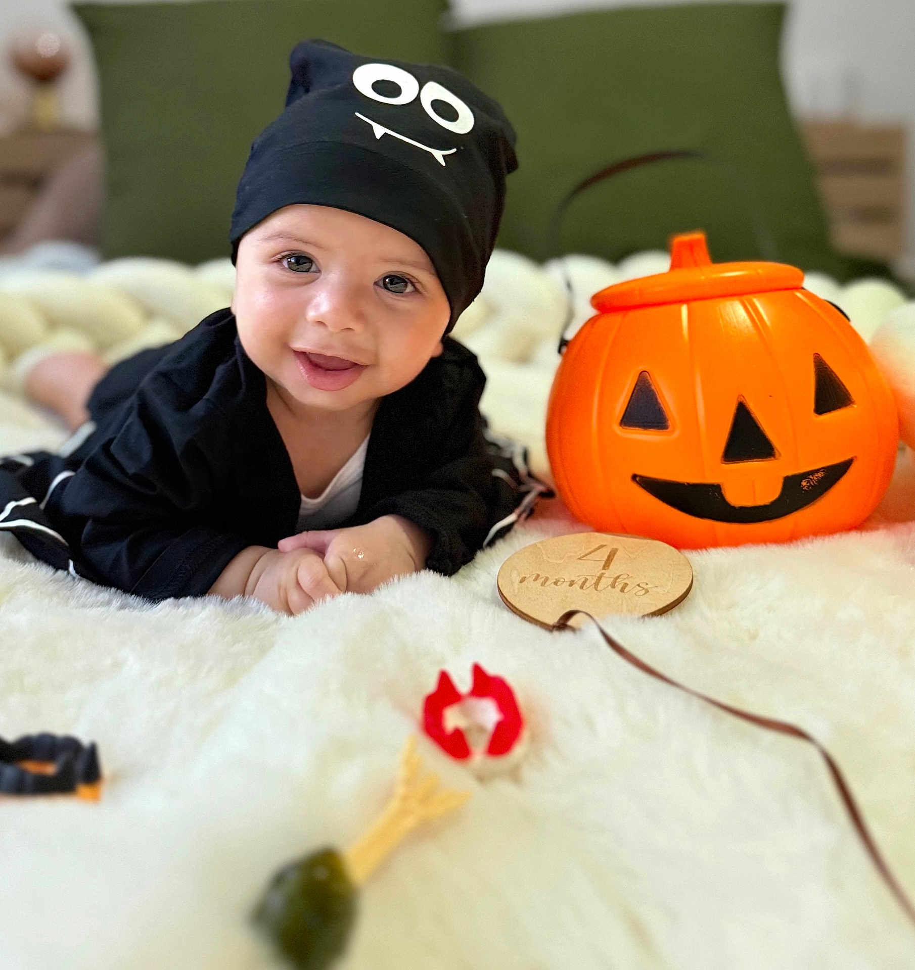 Ayane a rejoint le concours — aidez-le/la à gagner de superbes lots ! baby, infant, smiling, hat, black_clothing, pumpkin, orange, toy, plush_blanket, milestone, wooden_plaque, indoor, portrait, cute, child, face, happy, holiday, decor, lying_down