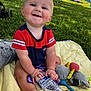 Noel joined the competition — help win amazing prizes! baby, child, grass, blanket, water_bottle, toy, outdoor, park, smiling, sitting, people, event, stroller, clothing, sunlight, happy, face, hand, foot, blue_eyes