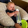 baby, sleeping, bottle, pillow, couch, toy, infant, child, face, hand, clothing, comfort, nap, indoor, peaceful, relaxation, furniture, cute, rest, young