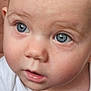 baby, baby_girl, blue_eyes, close_up, curious, cute, expression, face, fine_hair, hand, holding, human, infant, innocence, person, portrait, skin, soft_light, white_clothing, young_child
