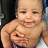 baby, child, smile, face, hand, skin, hair, cute, infant, swimwear, red_shorts, blue_shorts, holding, person, portrait, closeup, happy, sitting, indoors, young