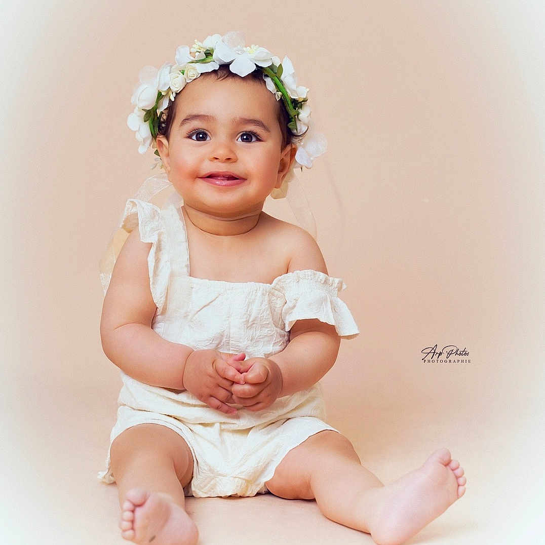 Louna a rejoint le concours — aidez-le/la à gagner de superbes lots ! accessories, baby, bodypart, clothing, dress, face, finger, flower, flowerarrangement, flowerbouquet, hand, happy, hat, head, person, photography, plant, portrait, sitting, smile