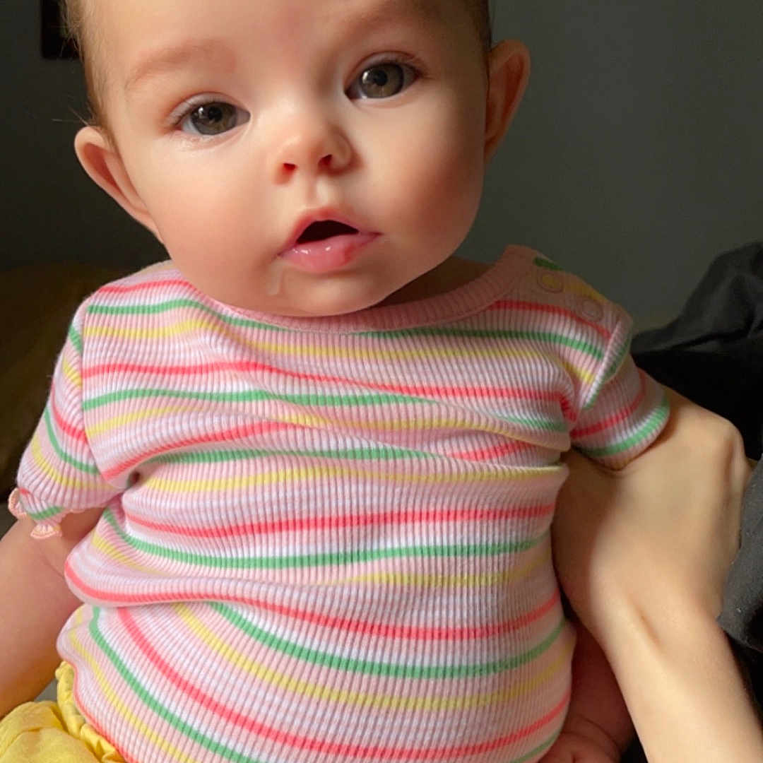 Ellie Ruth is registered to the contest to win money with this photo: baby, bodypart, clothing, couch, diaper, face, finger, furniture, hand, head, person, photoframe, photography, portrait, shorts, sitting, skin, sleeve, t_shirt, tattoo
