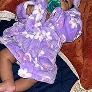 Zorah is registered to the contest to win money with this photo: baby, infant, pacifier, purple_robe, bunny_ears, blanket, cozy, cute, child, sleepwear, soft_texture, indoor, resting, apparel, foot, hand, face, portrait, comfort, young
