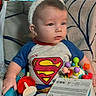 Walter joined the competition — help win amazing prizes! baby, bunny_ears, superman_shirt, blue_pants, lightning_pattern, toys, baby_seat, indoor, colorful, stained_glass, child, cute, sitting, portrait, clothing, infant, headwear, expression, person, home