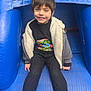 Kamren joined the competition — help win amazing prizes! child, boy, smiling, barefoot, blue, inflatable, slide, jacket, hoodie, tshirt, casual_clothing, playground, fun, outdoor, happy, person, sitting, leisure, cute, youth