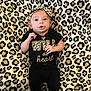Khaleesi joined the competition — help win amazing prizes! baby, infant, leopard_print, blanket, headband, clothing, black_outfit, gold_text, lying_down, cute, portrait, person, child, young, pattern, soft_texture, indoor, small_hands, looking_at_camera, cozy