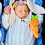 Remi joined the competition — help win amazing prizes! baby, sleeping, white_outfit, headband, floral, plush_toy, carrot, smiling, blanket, cozy, infant, cute, peaceful, soft, child, wrapped, hands, zipped, portrait, indoors