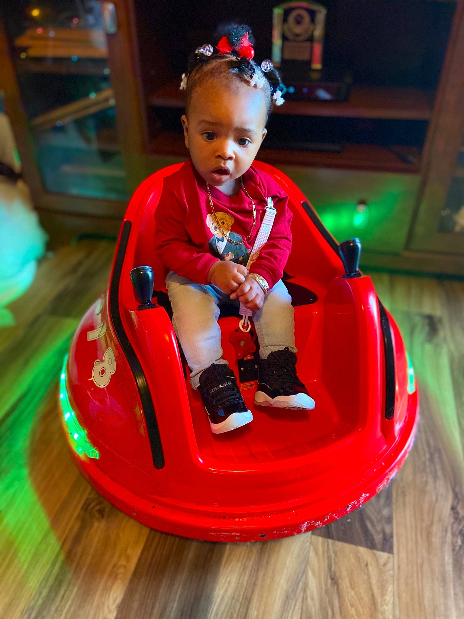 Alayla is registered to the contest to win money with this photo: amusement_park, amusement_ride, baby, baby_toddler_clothing, balance, bumper, child, person, play, playground, riding_toy, surprise, toddler, toy, wood_flooring