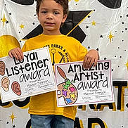 Mayson joined the competition — help win amazing prizes! child, award, certificate, yellow_shirt, jeans, standing, smile, background, graduation, stars, celebration, portrait, indoor, person, event, happy, recognition, art, listener, education