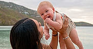 Matteo is registered to the contest to win money with this photo: baby, child, parent, outdoor, lakeside, water, hills, landscape, family, portrait, smiling, happy, infant, holding, lifting, arms, dress, romper, nature, sky