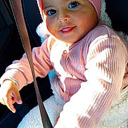 Ayana a rejoint le concours — aidez-le/la à gagner de superbes lots ! baby, child, headband, flower, pink_clothing, sweater, white_pants, car_seat, seatbelt, smiling, tongue_out, sunlight, cozy, cute, portrait, indoor, happy, infant, safe, closeup