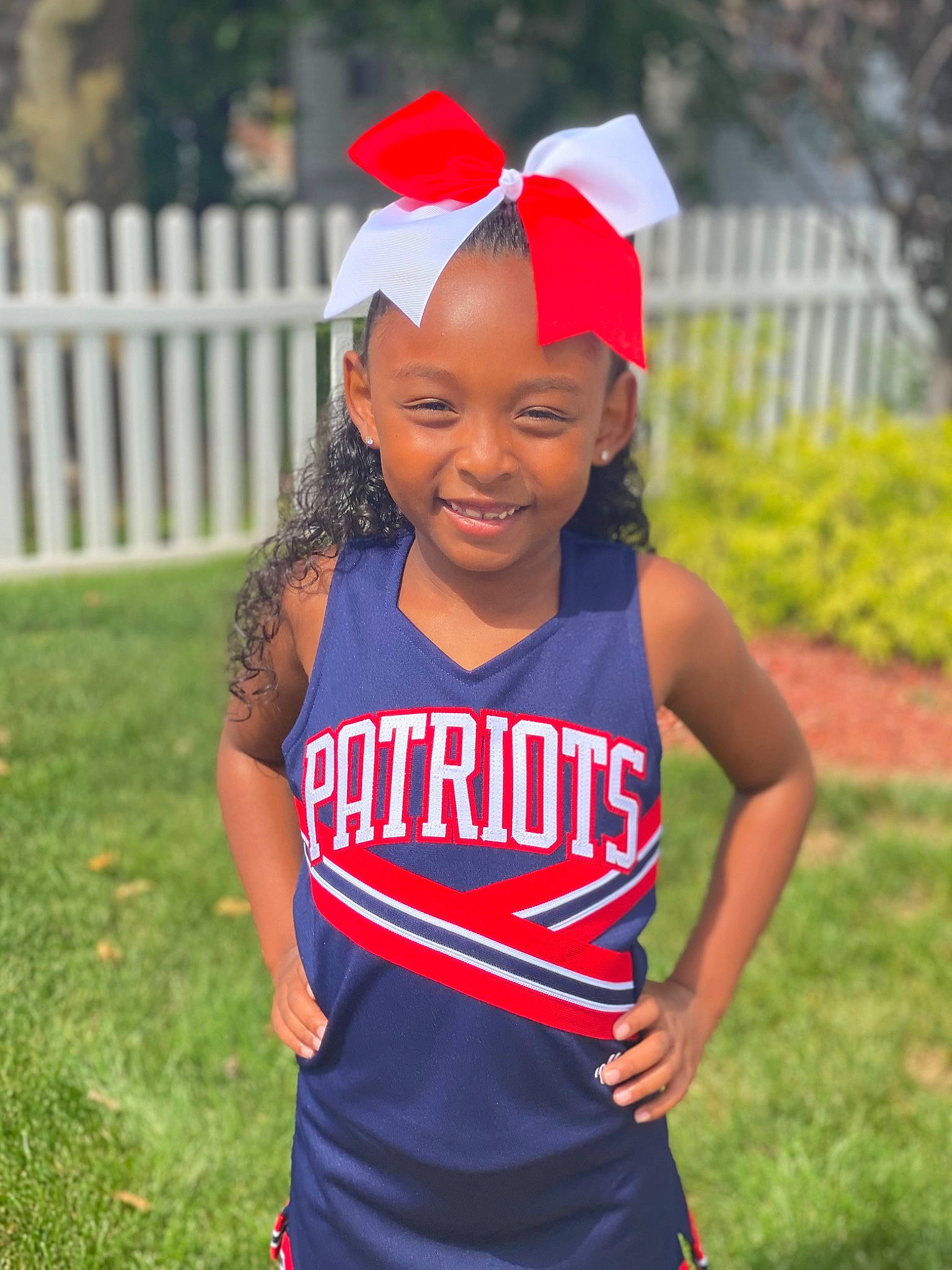 Ava is registered to the contest to win money with this photo: cap, chin, eye, face, fence, grass, happy, headband, headgear, headpiece, headwear, jersey, jewellery, joy, person, player, smile, sports_uniform, sportswear, t_shirt