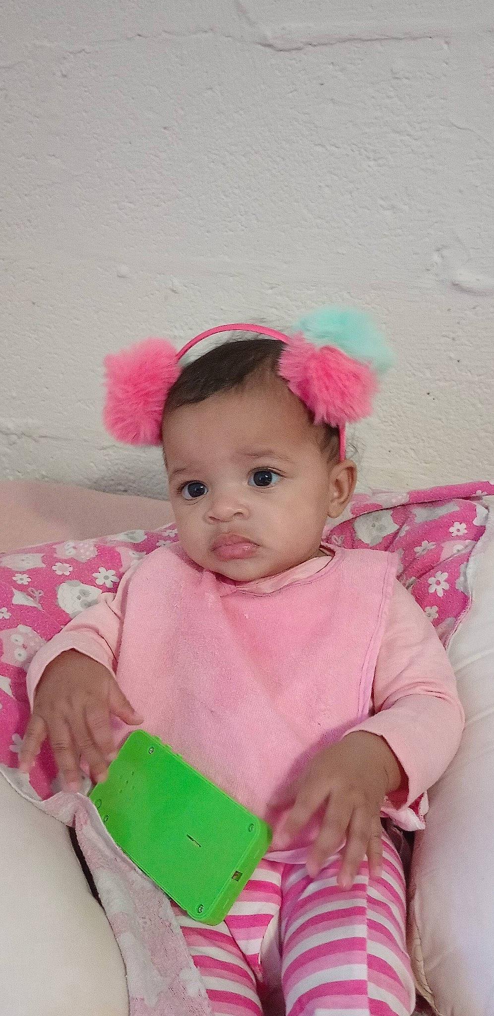 Xyla is registered to the contest to win money with this photo: baby, baby_playing_with_toys, baby_products, baby_toddler_clothing, cheek, child, dress, eyelash, fashion_accessory, happy, headband, headgear, lip, magenta, pattern, person, pink, sitting, skin, sleeve