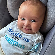 Lucius joined the competition — help win amazing prizes! baby, blue_eyes, car_seat, cheeks, child, closeup, clothing, comfortable, cute, face, graco, happy, indoors, infant, person, sitting, smile, text_on_clothing, white_shirt, young