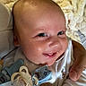 Lucius is registered to the contest to win money with this photo: baby, blanket, child, closeup, clothing, comfort, cute, face, hand, happy, holding, indoors, infant, newborn, pacifier, person, skin, smiling, soft, wearing