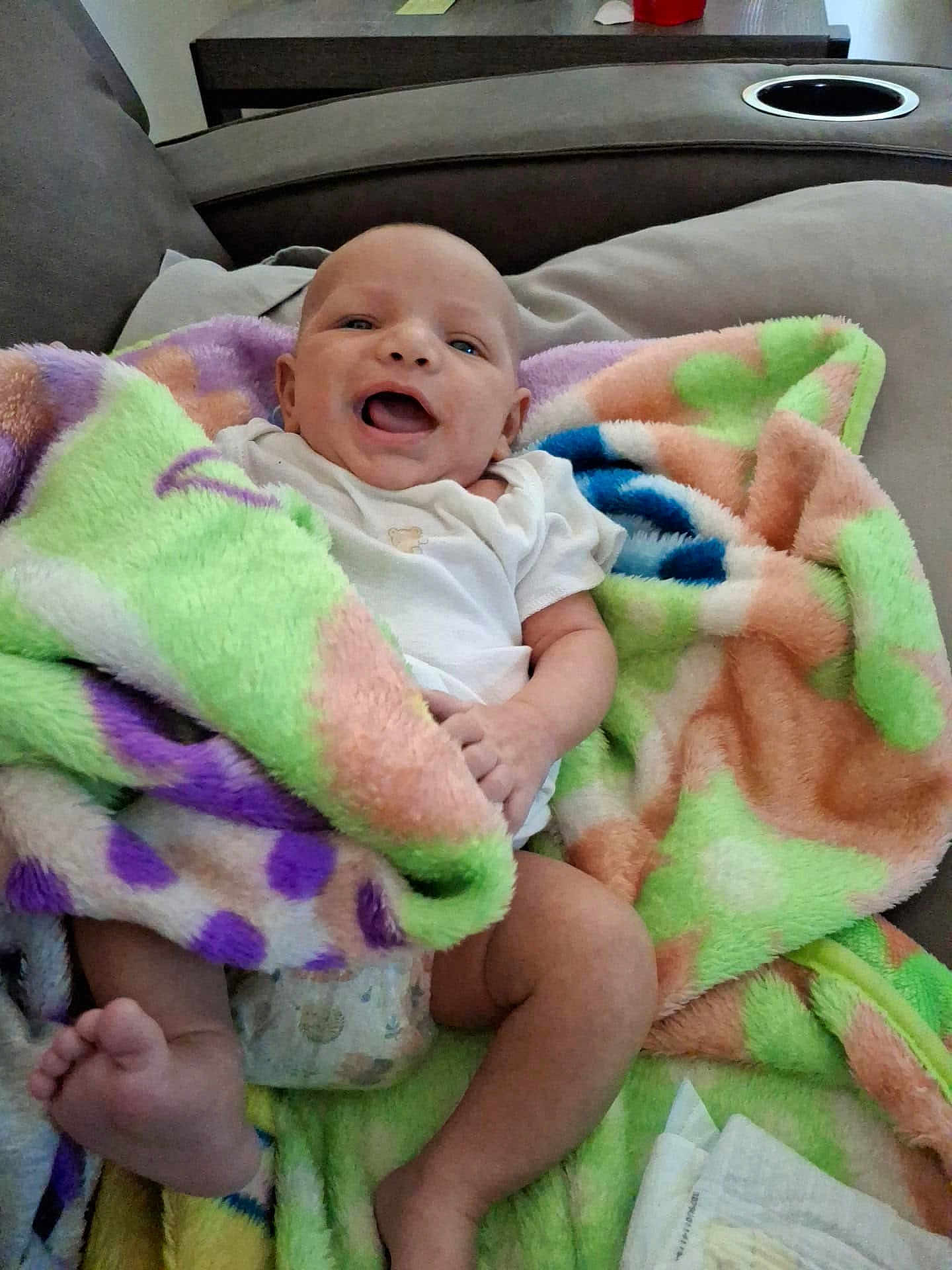 Steven joined the competition — help win amazing prizes! baby, blanket, couch, infant, smile, happy, face, person, home, colorful, fuzzy, clothing, diaper, foot, hand, relaxing, indoor, soft, comfort, joy