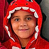 child, costume, dinosaur, hood, red, smile, face, portrait, person, cute, clothing, kid, happy, young, fashion, fun, indoor, headwear, expression, playful