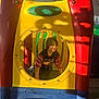 child, playground_equipment, plastic_tunnel, yellow_panel, red_panel, circular_window, smiling_child, crawling, indoor_play_area, sunlight, shadows, reflection, casual_clothing, graphic_tshirt, medium_hair, play_center, screws, colorful, floor, toy_area