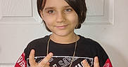 Austin joined the competition — help win amazing prizes! brown_hair, casual_clothing, child, closeup, eyes, flash_photography, front_facing, graphic_tshirt, hand_gesture, indoor, necklace, peace_sign, person, portrait, pose, short_hair, smile, tshirt, white_door, young_child
