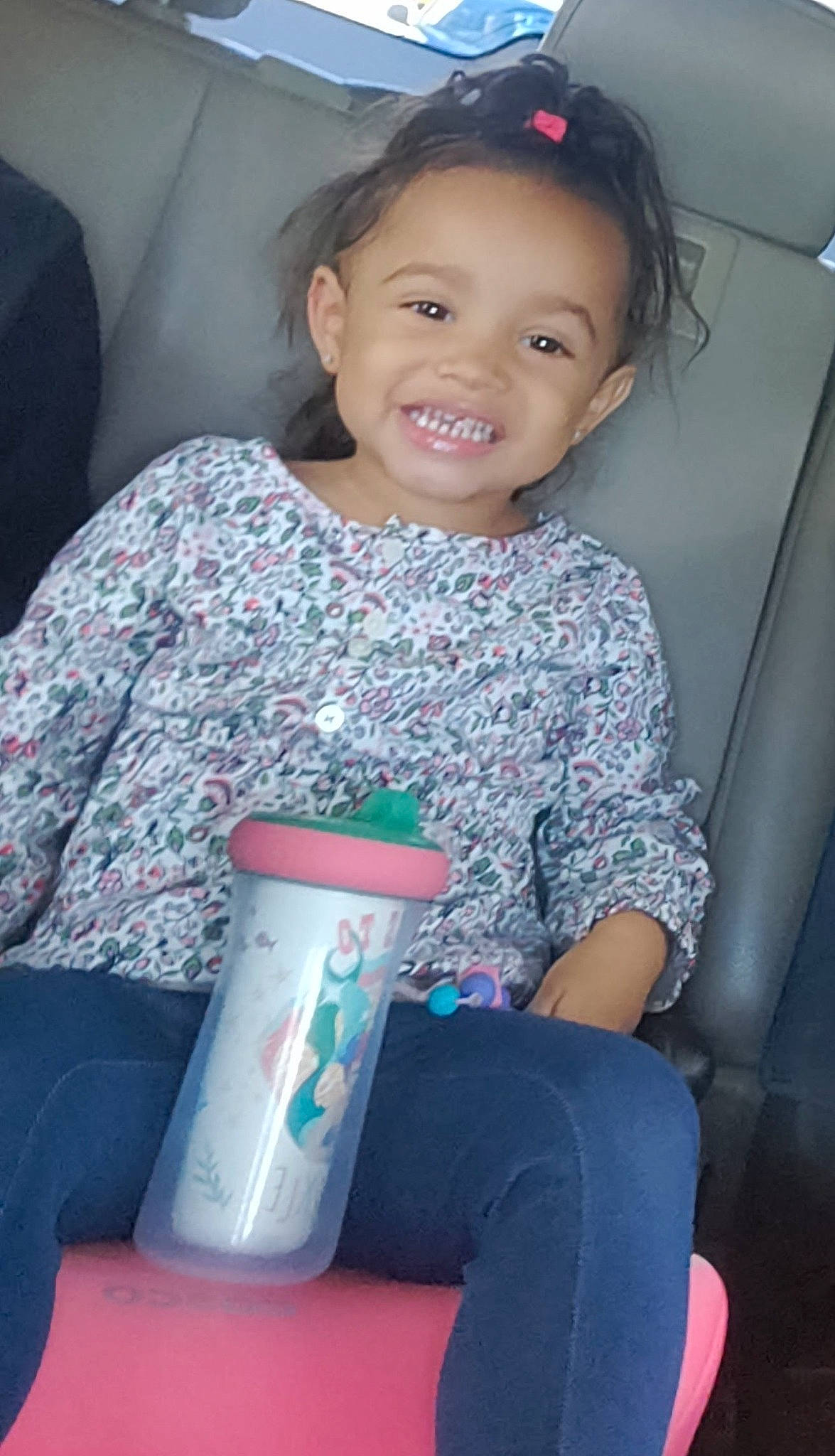 Azalee is registered to the contest to win money with this photo: beauty, car_seat, child, drinkware, electric_blue, eye, fun, hair, hairstyle, happy, human_leg, joy, knee, person, plastic_bottle, skin, smile, standing, thigh, toddler