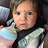 baby, bottle, car_seat, child, clothing, face, feeding, hair, hand, infant, indoors, person, portrait, seatbelt, straps, toddler, young_child, expression, closeup, pink