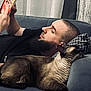 Chuck participe au concours pour gagner de l'argent avec cette photo : man, beard, reading, book, cat, siamese_cat, couch, pillow, relaxing, indoor, home, furniture, pet, animal, resting, casual, comfort, leisure, side_profile, portrait