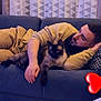 Chuck a rejoint le concours — aidez-le/la à gagner de superbes lots ! man, cat, siamese_cat, couch, blue_couch, pillow, curtains, geometric_pattern, relaxing, indoor, living_room, beard, casual_clothing, yellow_sweater, resting, pet, heart_emoji, hand, face, comfort