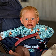 Alezio participe au concours pour gagner de l'argent avec cette photo : toddler, child, stroller, blue_eyes, chocolate_mess, clothing, seatbelt, hand, foot, face, hair, indoor, table, fabric, person, sitting, cute, infant, baby, expression