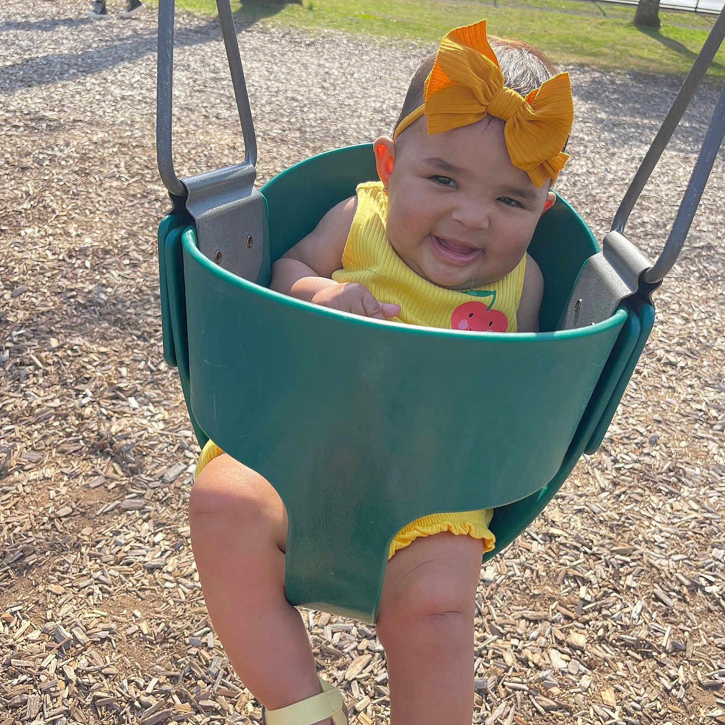 Nova is registered to the contest to win money with this photo: baby, bench, clothing, face, footwear, furniture, grass, hat, head, nature, outdoorplayarea, outdoors, park, person, photography, plant, playarea, portrait, sandal, shoe