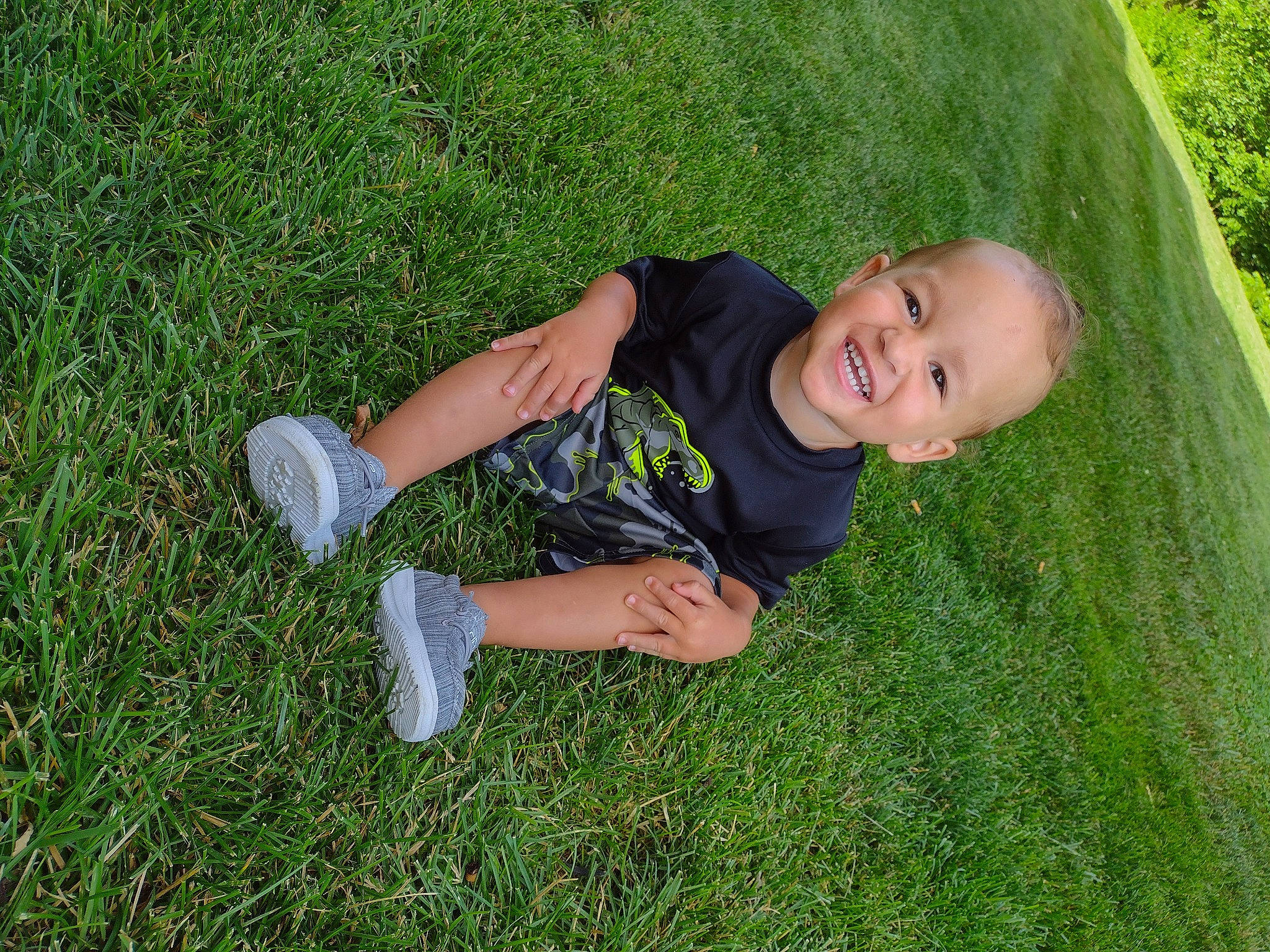 Maison is registered to the contest to win money with this photo: child, flooring, fun, grass, grass_family, grassland, groundcover, happy, joy, lawn, leisure, mammal, meadow, people_in_nature, person, plant, prairie, sitting, smile, t_shirt