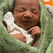 Julius is registered to the contest to win money with this photo: newborn, baby, infant, sleeping, blanket, green, soft, cute, smiling, wrapped, cozy, hands, face, peaceful, portrait, child, young, indoors, resting, toddler