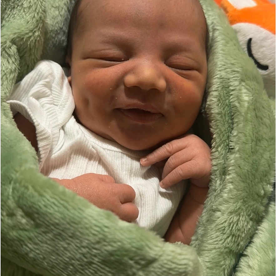 Julius is registered to the contest to win money with this photo: newborn, baby, infant, sleeping, blanket, green, soft, cute, smiling, wrapped, cozy, hands, face, peaceful, portrait, child, young, indoors, resting, toddler