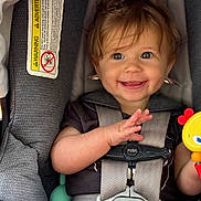 Camden joined the competition — help win amazing prizes! baby, child, car_seat, smile, happy, toy, infant, seatbelt, clothing, hair, face, hand, sitting, safety, cute, young_child, indoor, child_safety, portrait, infant_toy